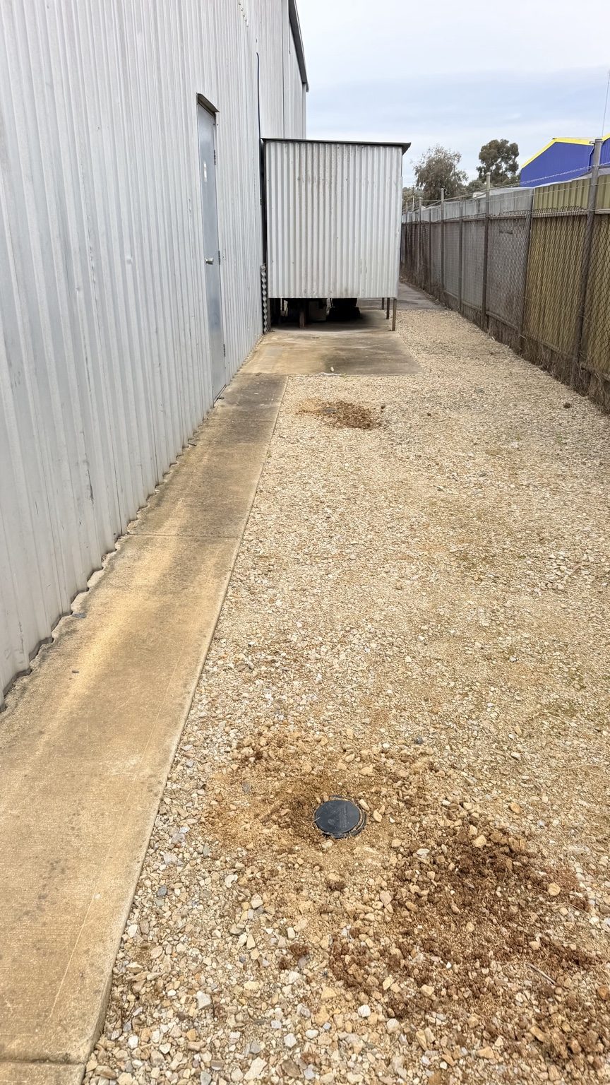 Termite station installed in gravel beside the warehouse